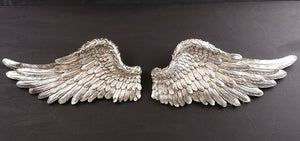 Distressed silver resin wings displayed on an interior wall
