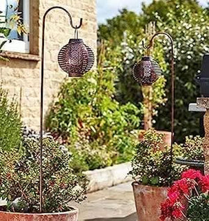 Two flickering LED lights hanging from garden hooks