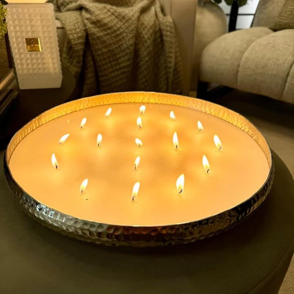 Large round candle with multiple small candles inside on a dark surface