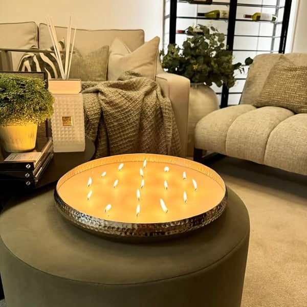 Round fire pit table with glowing candles in a living room setting