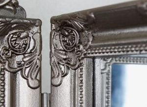 Ornate silver dressing mirror displayed on a vanity table