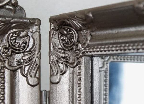 Ornate silver dressing mirror displayed on a vanity table