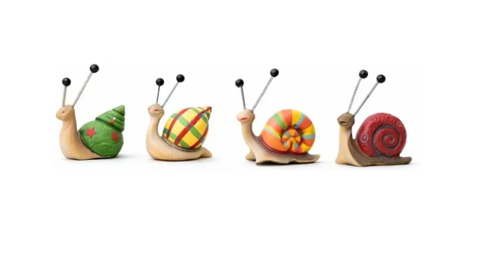 Colourful resin snail garden ornaments on patio display