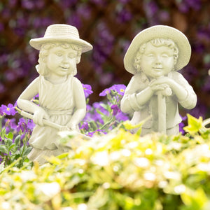 Two gardening children ornaments holding garden tools