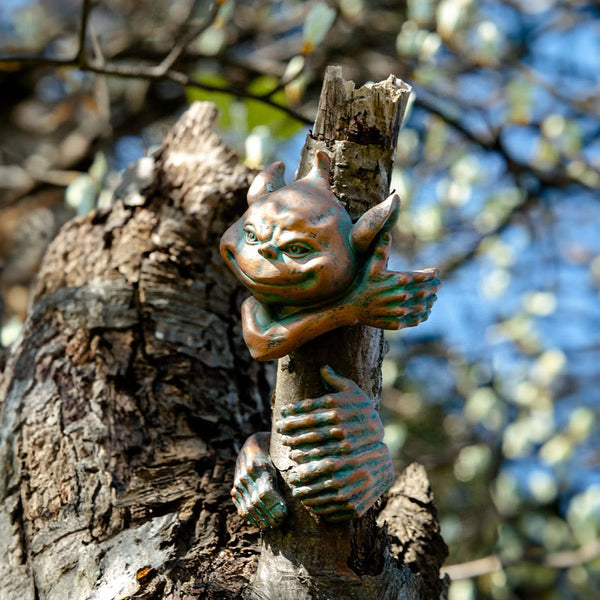 Goblin face and hands mounted on a garden tree