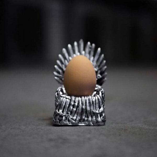 Egg in a silver throne-like holder on a dark background
