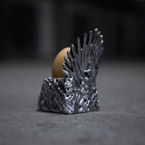Metallic throne-like object with a brown sphere on a dark background