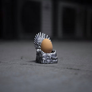 Egg on a miniature Iron Throne model against a dark background