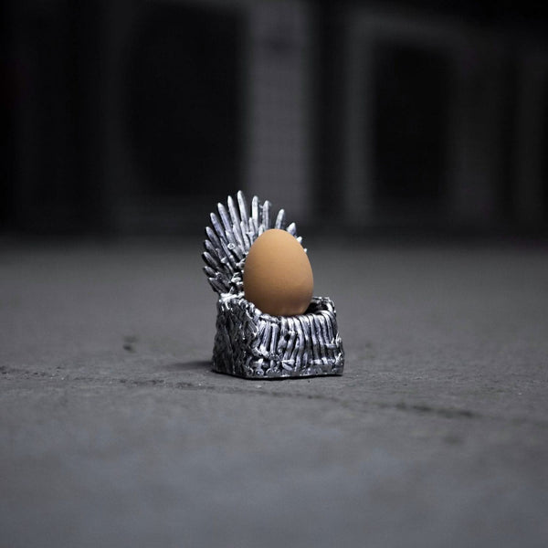 Egg on a miniature Iron Throne model against a dark background