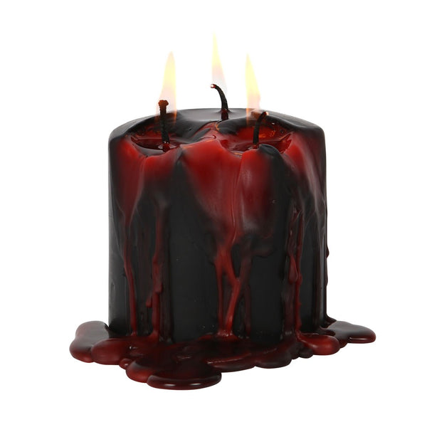 Black candle with red wax dripping on a white background