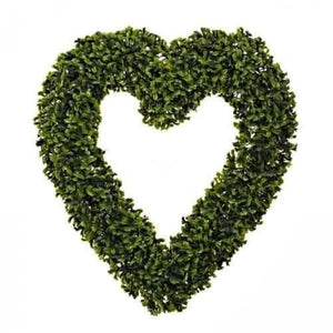 Artificial greenery heart displayed against a garden wall