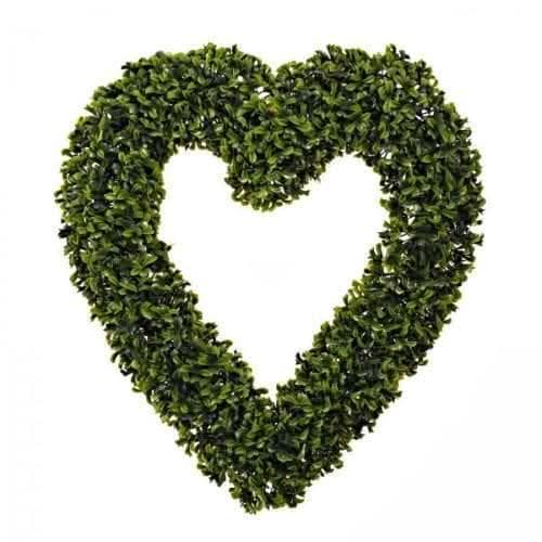 Artificial greenery heart displayed against a garden wall