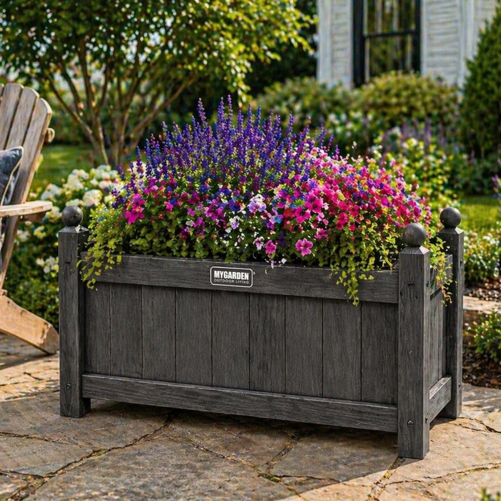 Grey wooden garden planter with colourful flowering plants.