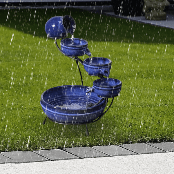 Royal blue ceramic water feature surrounded by plants