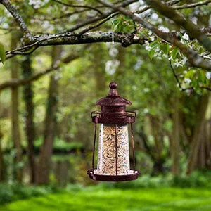Decorative lighthouse lantern bird feeder hanging outdoors