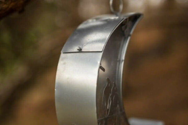 Silver moon feeder hanging from garden tree