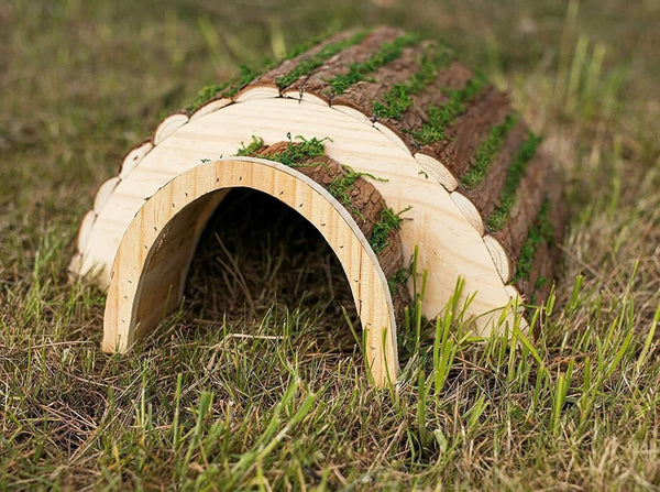 Hedgehog house with curved bark and grass roof