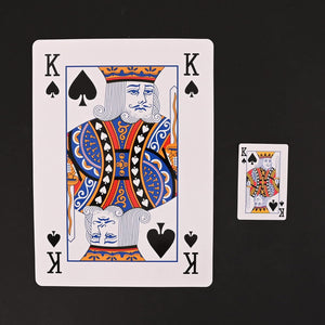 Oversized playing cards displayed inside a storage box.