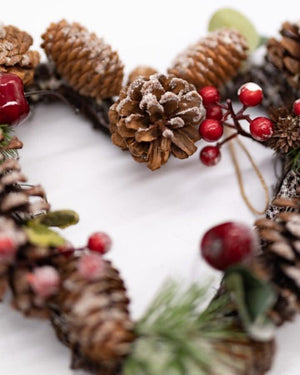 Artificial greenery heart wreath hanging on an interior wall