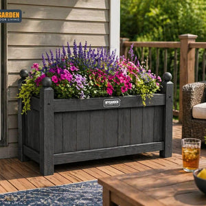 Wooden plant container placed beside a garden pathway.