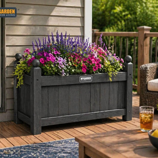 Wooden plant container placed beside a garden pathway.