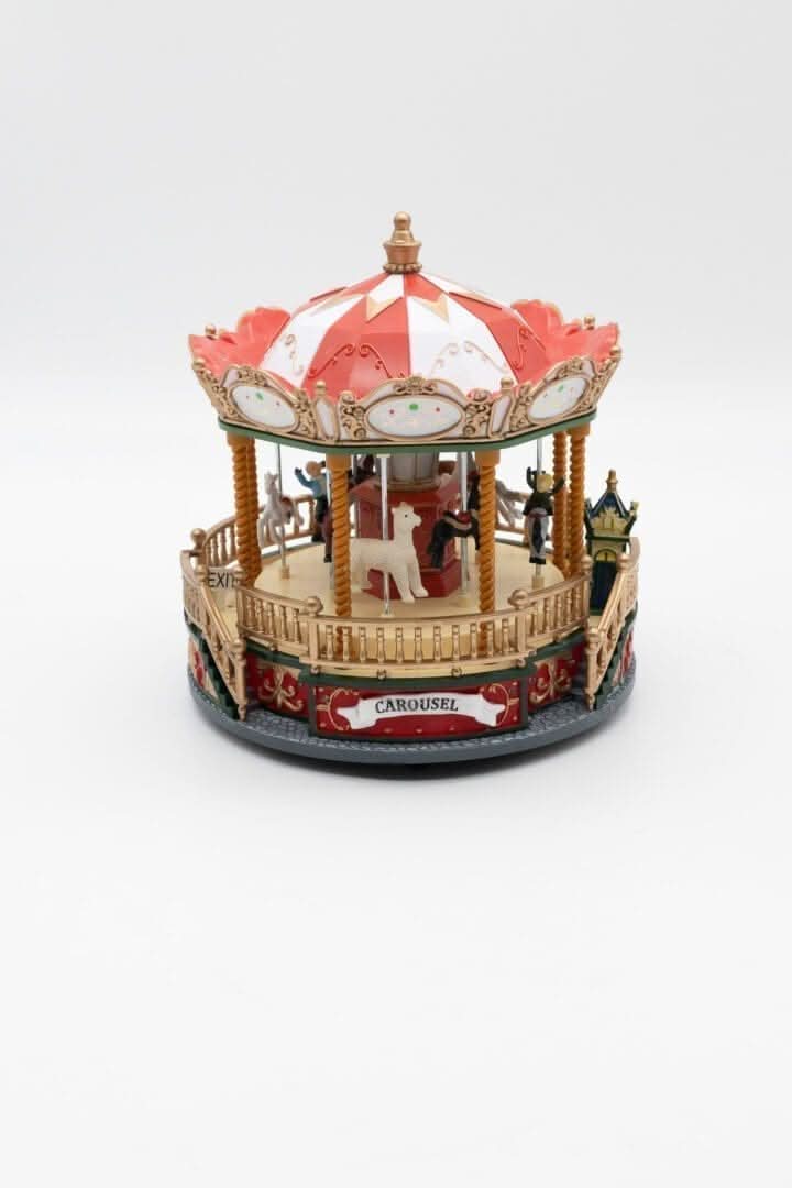 A colorful LED lit carousel Christmas decoration featuring holiday-themed figures and intricate detailing.