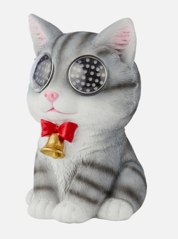 Resin cat ornament with illuminated LED eyes outdoors