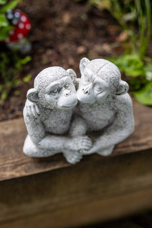 Kissing monkeys ornament displayed on an indoor shelf