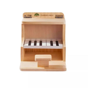 Piano shaped wooden bird feeder shown outdoors