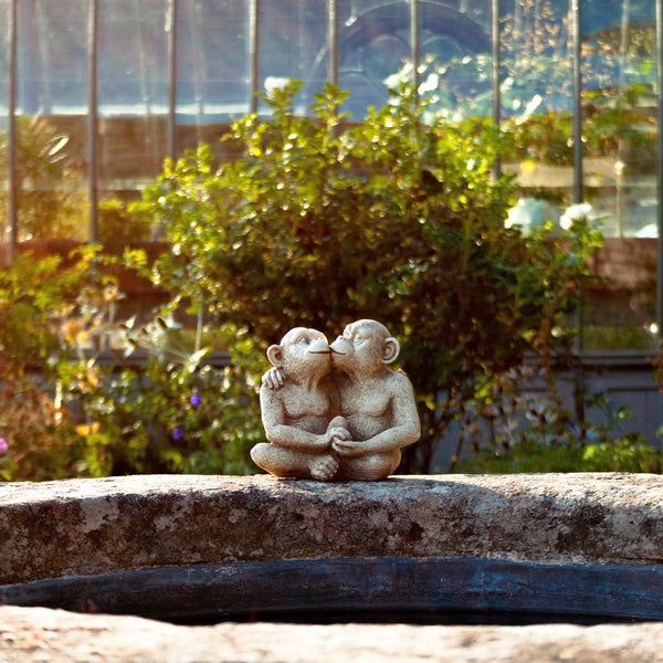 Detailed monkey couple sculpture surrounded by greenery