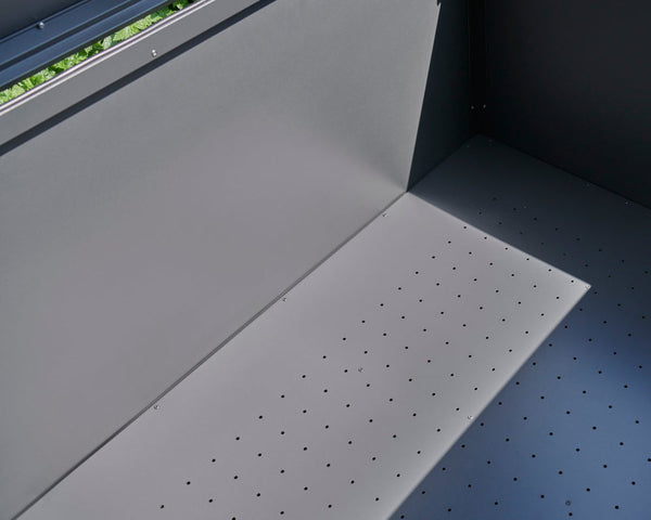 Gray pegboard with holes on a blue wall