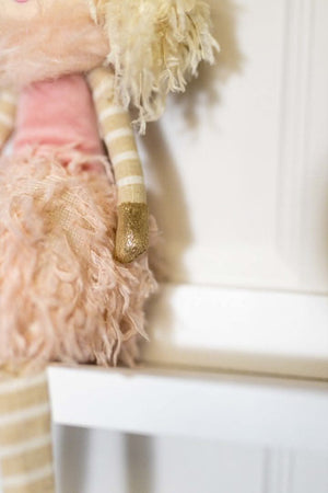 Plush pink winter fairy displayed beside Christmas tree