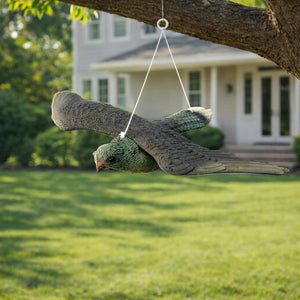 Flying predator decoy displayed above a garden