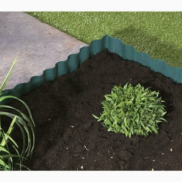 Green plastic wavy lawn edging roll in garden border