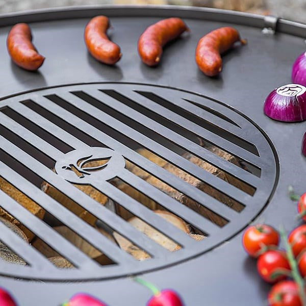 Grill with sausages and vegetables on a metal surface