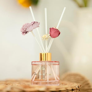 Reed diffuser with floral design on a neutral background