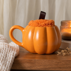 Pumpkin shaped mug with pair of fluffy autumn socks