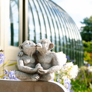 Cute kissing monkeys positioned near a garden entrance