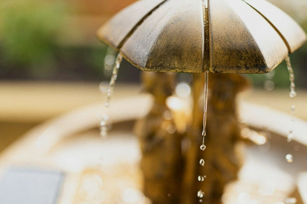 Freestanding resin water feature surrounded by plants