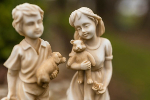 Pair of child statues displayed in a garden