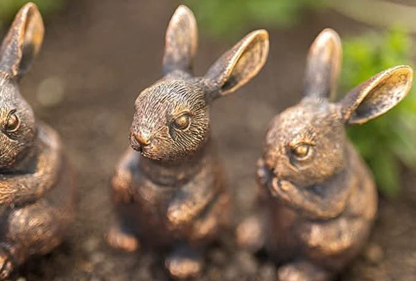 Bronze rabbit family garden ornaments displayed together