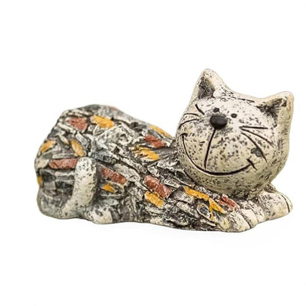 Resin cat ornament positioned beside outdoor plants