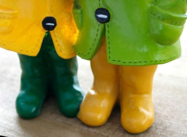 Colourful duck couple wearing raincoats and carrying umbrellas