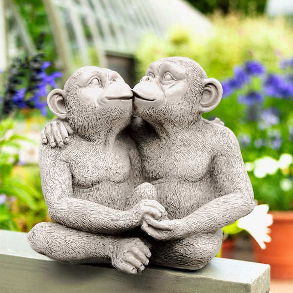 Pair of monkey statues sharing a kiss