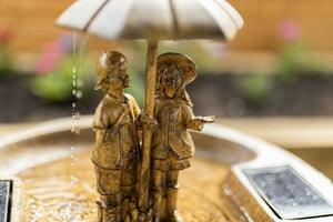 Decorative fountain positioned beside garden seating