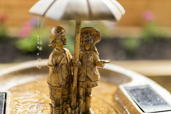 Decorative fountain positioned beside garden seating