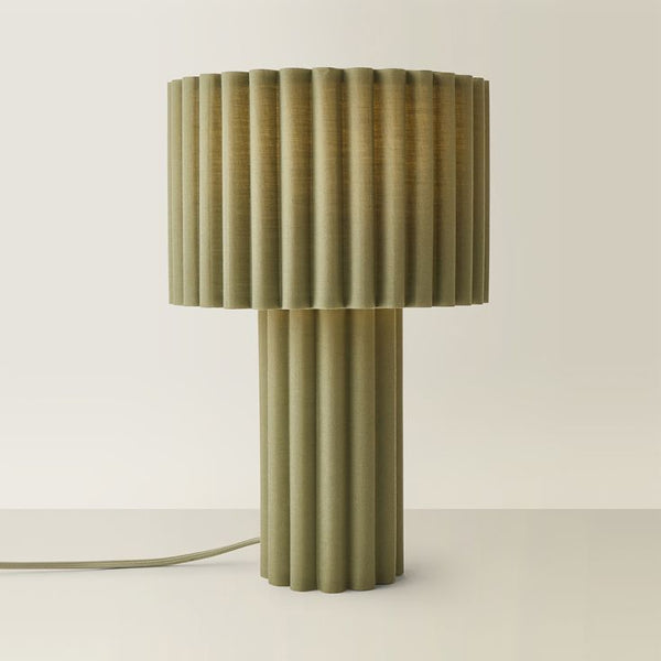 Decorative table lamp with ribbed design on a plain background
