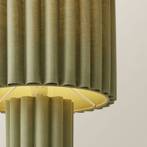 Close-up of a green textured lampshade on a neutral background