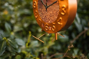 Copper garden bird feeder hanging from tree