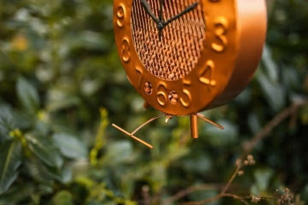 Copper garden bird feeder hanging from tree